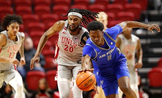 UNLV forward Keylan Boone (20) and Air Force guard Byron Brown (11) chase after the ball during the second half of an NCAA basketball game at the Thomas & Mack Center Tuesday, Jan. 23, 2024.