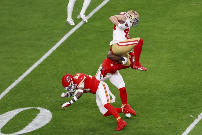 San Francisco 49ers fullback Kyle Juszczyk (44) jumps over Kansas City Chiefs safety Mike Edwards (21) as Kansas City Chiefs linebacker Nick Bolton (32) tackles him during the first half of the NFL Super Bowl 58 football game at Allegiant Stadium in Las Vegas Sunday, Feb. 11, 2024.
