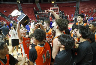 Bishop Gorman guard Ryder Elisaldez (24) holds up the trophy as Bishop Gorman players celebrate after defeating Coronado 63-60 in the boys Class 5A state basketball championship at the Thomas & Mack Center Friday, Feb. 23, 2024.