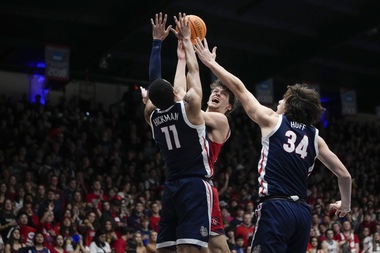 Saint Mary’s guard Aidan Mahaney, center, shoots while defended by Gonzaga guard Nolan Hickman (11) and forward Braden Huff (34) during the first half of an NCAA college basketball game Saturday, March 2, 2024, in Moraga, Calif.