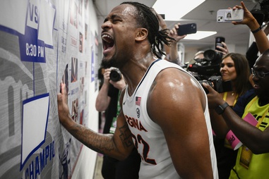 Virginia forward Jordan Minor (22) reacting as he places the decal on the bracket board after defeating Boston College in overtime in an NCAA college basketball game in the quarterfinal round of the Atlantic Coast Conference tournament Thursday, March 14, 2024, in Washington. Virginia won 66-60. 

