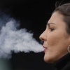 A woman smokes on a street, in London, Tuesday, April 16, 2024. A bold plan to ban anyone born after 2008 from ever legally buying cigarettes in Britain faces its first test in Parliament. The bold plan has divided the governing Conservatives, with some hailing its public health benefits and others condemning it as state overreach. 

