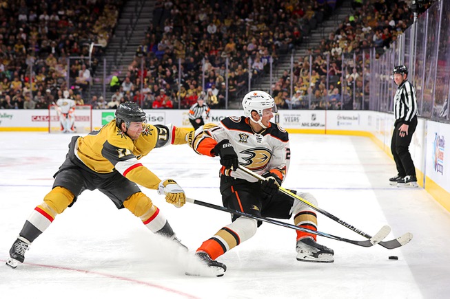 Vegas Golden Knights defenseman Ben Hutton (17) and Anaheim Ducks center Isac Lundestrom (21) fight for the puck during the second period of an NHL hockey game at T-Mobile Arena Thursday, April 18, 2024.