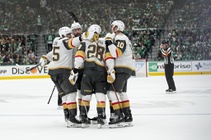 Vegas Golden Knights players surround Noah Hanifin after he scored against the Dallas Stars during the second period in Game 2 of an NHL hockey ...