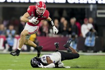 Georgia tight end Brock Bowers (19) leaps over TCU safety Millard Bradford (28) during the second half of the national championship NCAA College Football Playoff ...