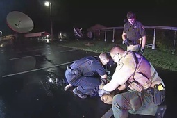 In this image from Altoona Police Department body-camera video, police restrain Demetrio Jackson in a parking lot on the border of Altoona and Eau Claire, Wis., on Oct. 8, 2021, minutes before a paramedic injects him with ketamine. Five medical experts who reviewed the case for AP said Jackson’s behavior did not appear to be dangerous enough to justify the use of ketamine.