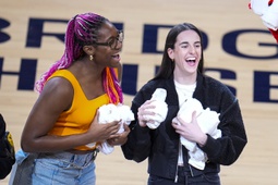 Indiana Fever players Aliyah Boston, left, and Caitlin Clark throw tee-shirts to fans during a time out during the first half between the Indiana Pacers and the Milwaukee Bucks in Game 2 in an NBA basketball first-round playoff series, Friday, April 26, 2024, in Indianapolis. 