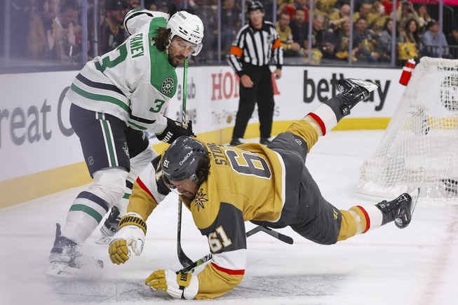 Vegas Golden Knights right wing Mark Stone (61) trips as Dallas Stars defenseman Chris Tanev (3) reaches for the puck during the first period of Game 6 of an NHL hockey Stanley Cup first-round playoff series at T-Mobile arena Friday, May 3, 2024.