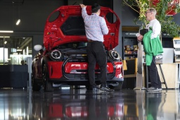 A salesperson shows an unsold 2024 Cooper SE electric hardtop to a prospective buyer at a Mini dealership Wednesday, May 1, 2024, in Highlands Ranch, Colo.