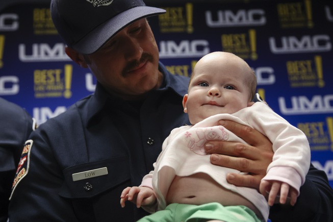 Three-month-old Johanna Spellacy is held by Las Vegas Fire & Rescue paramedic Chaisson Low during a press conference at the UMC Trauma Center Tuesday, May 7, 2024. Johanna’s life was saved on Feb. 7 when Las Vegas Fire & Rescue paramedics relieved constriction to her umbilical cord when she wasn’t getting enough oxygen during a breech birth.
