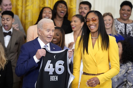 A'ja Wilson, of the WNBA's Las Vegas Aces, right, presents a jersey to President Joe Biden during an event to celebrate the 2023 WNBA championship team, in the East Room of the White House, Thursday, May 9, 2024, in Washington.