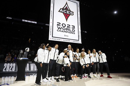 Las Vegas Aces players and coaches pose in front of a banner during a ceremony before an WNBA basketball game against the Phoenix Mercury at Michelob Ultra Arena in Mandalay Bay on Tuesday, May 14, 2024.