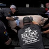 Shaun Stecklein, left, Jeff Fritz, Nick Ray and Buddy Aucoin, right, of The Shed BBQ and Blues Joint team load a whole hog into a cooker as they compete at the World Championship Barbecue Cooking Contest, Friday, May 17, 2024, in Memphis, Tenn.


