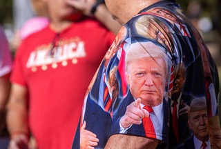 Geovanni Ghiloni of Las Vegas wears a shirt covered in photos of former President Donald Trump as he waits in line for a Donald Trump campaign rally at Sunset Park Sunday, June 9, 2024.
