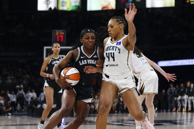 Las Vegas Aces guard Jackie Young (0) tries to move the ball against New York Liberty forward Betnijah Laney-Hamilton (44) during the first half of a WNBA basketball game Saturday, June 15, 2024, in Las Vegas.