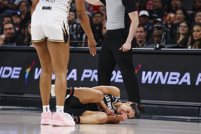 Las Vegas Aces guard Kelsey Plum (10) falls to the floor after getting hit during the first half of a WNBA basketball game against the New York Liberty Saturday, June 15, 2024, in Las Vegas.