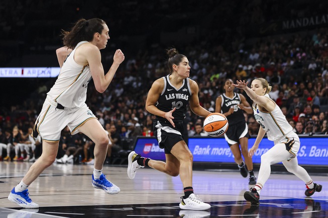 Las Vegas Aces guard Kelsey Plum (10) moves the ball against New York Liberty forward Breanna Stewart (30) and  New York Liberty forward Leonie Fiebich (13) during the first half of a WNBA basketball game Saturday, June 15, 2024, in Las Vegas.