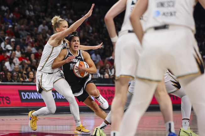 Las Vegas Aces guard Kelsey Plum (10) tries to move the ball against New York Liberty forward Leonie Fiebich (13) during the second half of a WNBA basketball game Saturday, June 15, 2024, in Las Vegas.