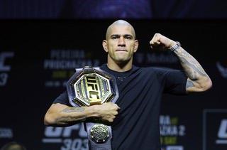 UFC light heavyweight champion Alex Pereira poses with his belt during an UFC 303 news conference Thursday, June 27, 2024. Pereira is scheduled to defend his title against Jiri Prochazka at the arena on Saturday.