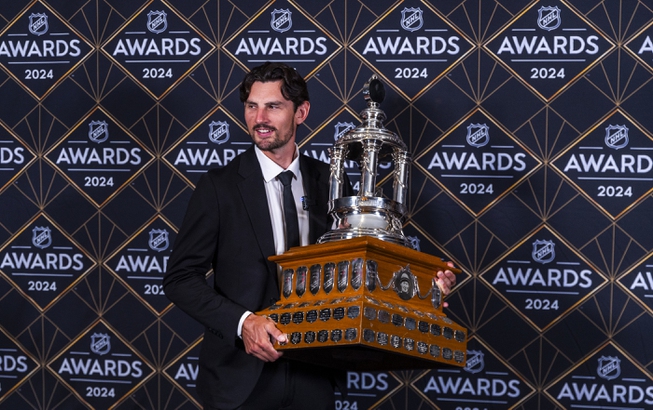 Winnipeg Jets goaltender Connor Hellebuyck holds the Vezina Trophy at hockey's NHL Awards, Thursday, June 27, 2024, in Las Vegas. 


