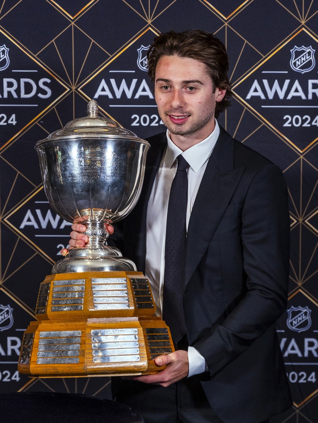 Vancouver Canucks defenseman Quinn Hughes holds the James Norris Memorial Trophy at hockey's NHL Awards, Thursday, June 27, 2024, in Las Vegas. 

