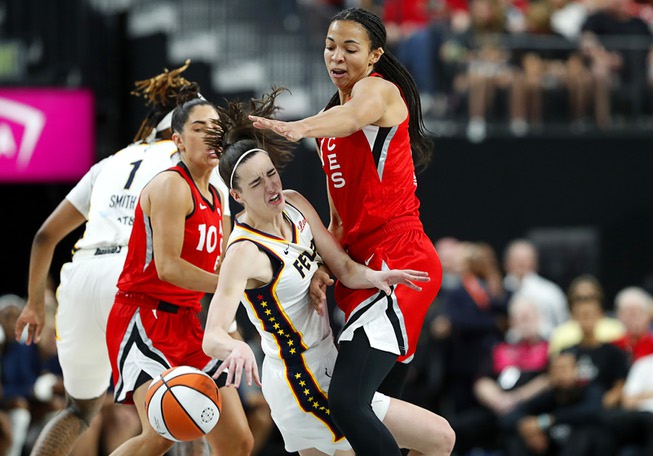 Indiana Fever guard Caitlin Clark (22) is fouled by Las Vegas Aces center Kiah Stokes (41) during the first half of an WNBA basketball game t T-Mobile Arena Tuesday, July 2, 2024. Las Vegas Aces guard Kelsey Plum (10) looks on at left.