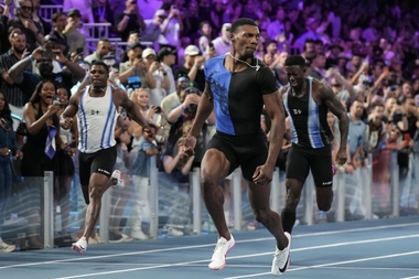 Fred Kerley ran 100 meters in a pedestrian 9.97 seconds Sunday night to win the Enhanced Games in a race where the sprinters had to be placed in the starting blocks four times because of false starts and untied shoes.