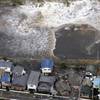 A tsunami approaches seashore houses in Kita Ibaraki, Ibaraki Prefecture, northeast of Tokyo, Friday, March 11, 2011.