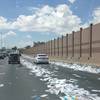 Papers litters Interstate 15 between Sahara Avenue and Charleston Boulevard after a box fell from a truck and was hit by a bus Tuesday, July 24, 2012.