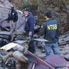 In this photo provided by the National Transportation Safety Board on Saturday, Dec. 10, 2011, investigators examine the wreckage of a sightseeing tour helicopter from Las Vegas that crashed in the Lake Mead National Recreation Area in Nevada near the Hoover Dam. The Wednesday, Dec. 7, 2011, crash killed the pilot and four tourists, including a couple from Kansas and a couple from New Delhi, India. 