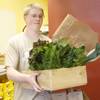 Wes Zarnowitz packs a wooden crate with fresh fruit and vegetables for a customer at Trish & Ed's Organics, Wednesday, March 6, 2013.
