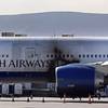 A British Airways passenger jet is surrounded by emergency vehicles after a fire Tuesday, Sept. 8, 2015, at McCarran International Airport.