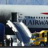 Firefighters stand by a British Airways plane that caught fire Tuesday, Sept. 8, 2015, at McCarran International Airport. An engine on the plane caught fire before takeoff, forcing passengers to escape on emergency slides.