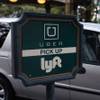 In this Jan. 14, 2016, photo, a driver waits to pick up passengers at an Uber and Lyft pickup area at the Bellagio in Las Vegas.