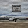 n this May 17, 2016, photo, a sign warns against trespassing as a plane lands at McCarran International Airport in Las Vegas.