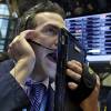 Gregory Rowe, left, with Livermore Trading Group, keeps an eye on stock prices at the New York Stock Exchange, Friday, Jan. 8, 2016.