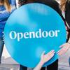 Members of the Opendoor national real estate firm pose for a photo in front of one of their properties.
