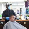 Chad Colom has his hair cut by owner Michael Jones at A Cut Above The Rest barber shop, 616 Carson Ave., Saturday, May 9, 2020. The barber shop is open for business by appointment.