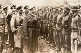 The June 3, 1944 photo provided by the US Holocaust Memorial Museum shows Heinrich Himmler, centre,  SS Reichsfuehrer-SS, head of the Gestapo and the Waffen-SS, and Minister of the Interior of Nazi Germany from 1943 to 1945, as he reviews troops of the Galician SS-Volunteer Infantry Division.   Michael Karkoc  a top commander whose Nazi SS-led unit is blamed for burning villages filled with women and children lied to American immigration officials to get into the United States and has been living in Minnesota since shortly after World War II, according to evidence uncovered by The Associated Press. Michael Karkoc became a member of the Galician division after the Ukrainian Self Defense Legion was incorporated into it near the end of the war.