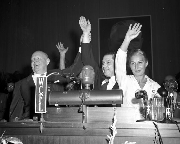 ** FILE ** Retiring Teamsters Union President Dave Beck, left, raises the hand of James R. Hoffa, who was elected to a five-year term as president of the International Brotherhood of Teamsters in Miami Beach, Fla. in this Oct 4, 1957 file photo. At right is Hoffa's wife Josephine. (AP Photo)