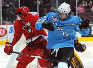 Alaska Aces defenseman Corey Syvret (right) collides with Wranglers center Geoff Paukovich during the third period of play on Saturday night.