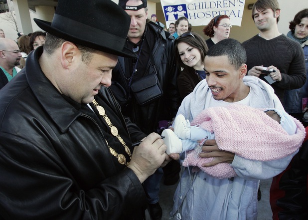 Actor James Gandolfini signs the shoe of Alvin Smith's 4-month-old daughter Ariann at Children's hospital in New Orleans, Friday, Feb. 16, 2007. Gandolfini will reign as king of the Mardi Gras parade which will roll through the streets of the Crescent City on Sunday night.
