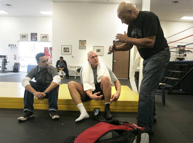 Trainer Richard Steele, right, gives some pointers to former UNLV basketball player Kaspars Kambala, center, after a sparring session. Noe Quintero looks on at left. Kambala is training for his upcoming debut as a professional boxer