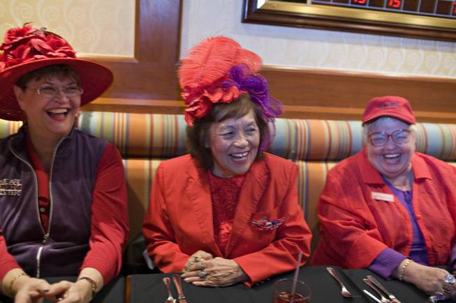 Red Hat Society members, from left, Anita Burchard, Edye Farran and Pat Hickok are gathered in the Cafe at Harrah’s to talk about the upcoming convention, the opening of the musical “Hats!” and a hoped-for record-setting chorus line. 
