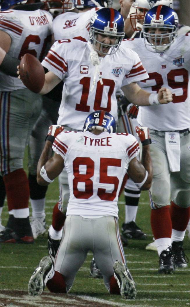 New York Giants quarterback Eli Manning (10) joins wide receiver David Tyree in celebration after the Giants’ 17-14 win over the New England Patriots in Super Bowl XLII.