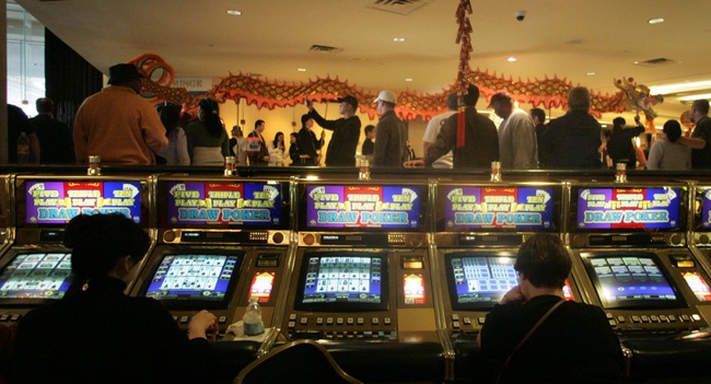 Gamblers keep playing their slots while members of the Lohan School of Shaolin perform a dragon dance  Las Vegas Hilton casino Saturday.