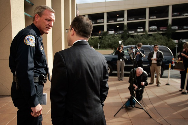 Henderson Police Chief Richard Perkins speaks with Henderson Police spokesman Keith Paul before Thursday’s news conference.