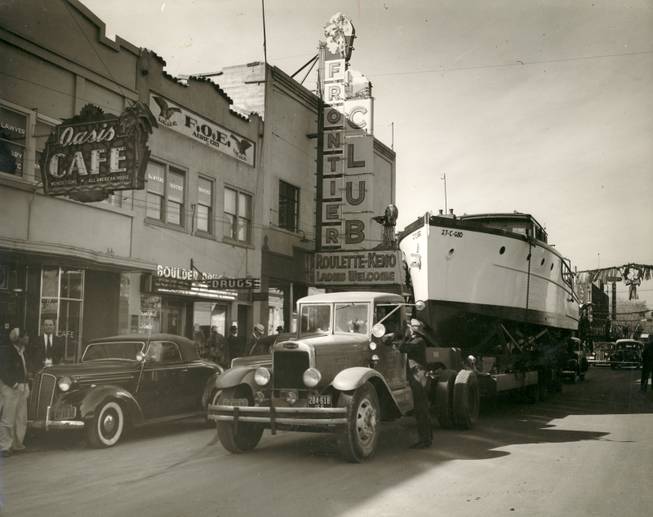 A truck tows a big boat down Fremont Street in ...