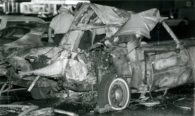 Investigators examine the area surrounding the twisted remnants of Frank "Lefty" Rosenthal's car after a bomb destroyed the vehicle on Oct. 4, 1982. A metal plate directly underneath the driver's seat of the Cadillac diverted the explosion away from Rosenthal, saving his life. 
