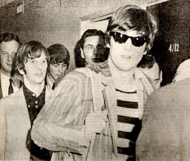 The Beatles are ushered to their room at the Sahara hotel before performing at the Las Vegas Convention Center on Aug. 20, 1964. John Lennon dons sunglasses and stands in front, with Ringo Starr on the left and George Harrison, looking down behind Ringo.